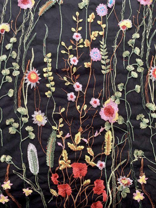Black fabric with colorful embroidered flowers
