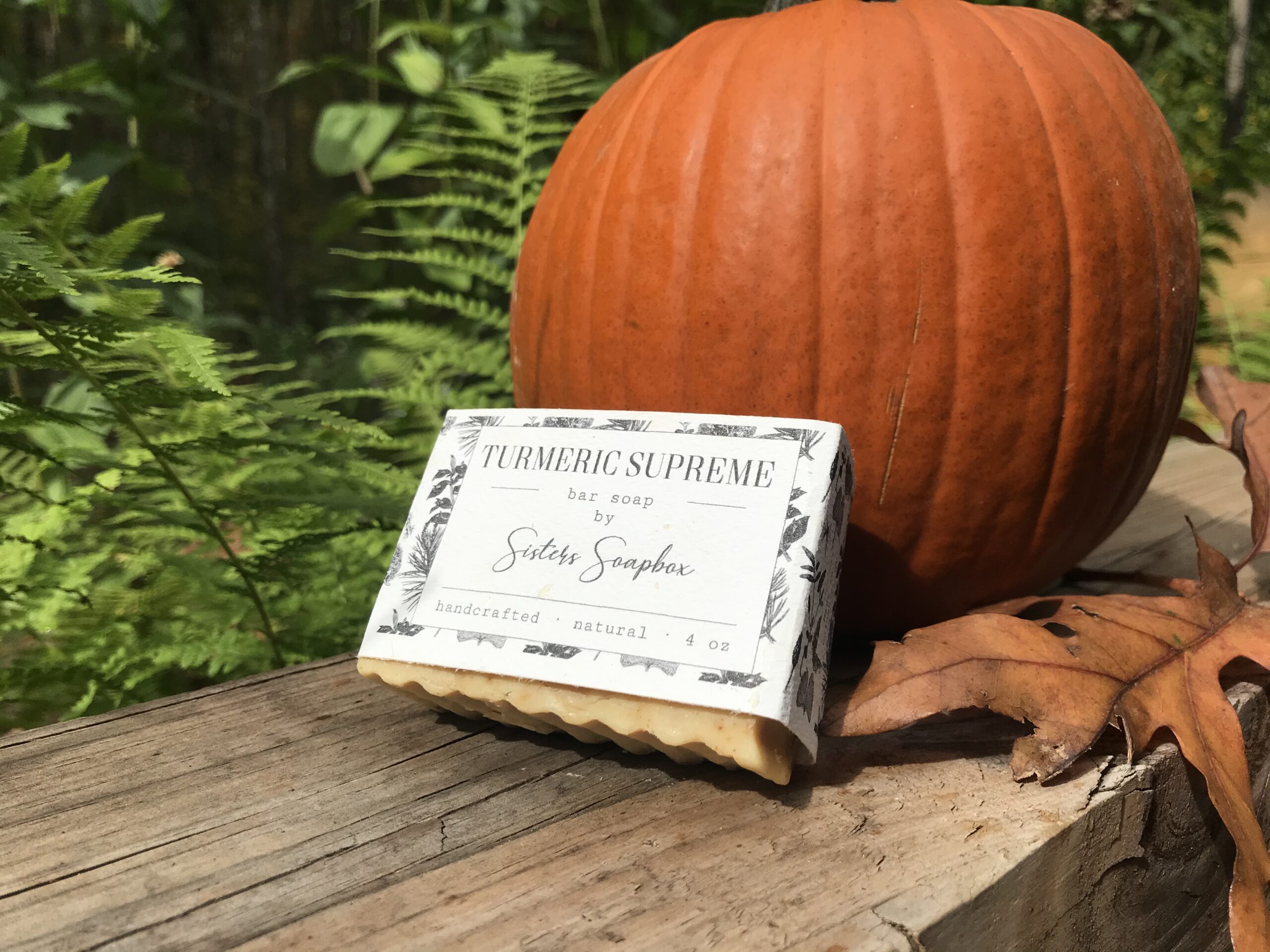 Turmeric Supreme Bar Soap leaning against a pumpkin