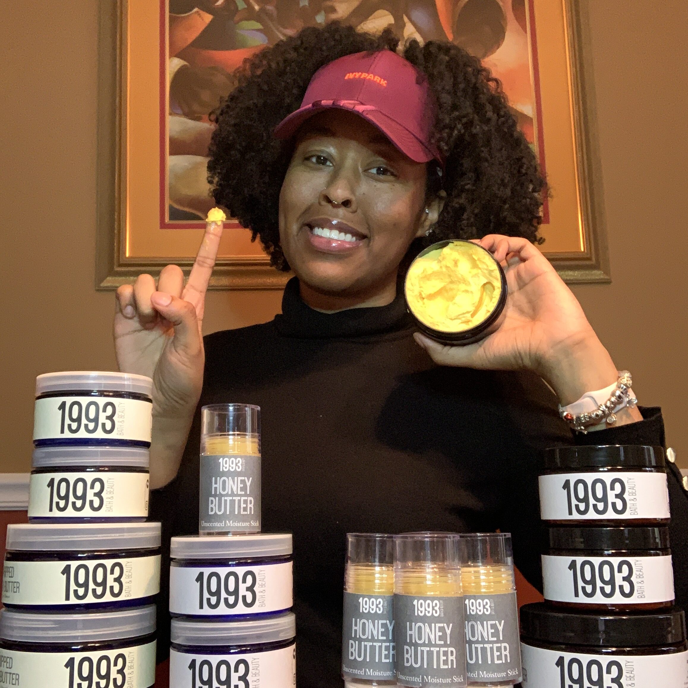 Beautiful Black woman with natural hair, holdng her products. 