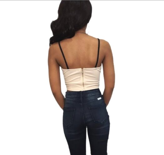 The back of the geometric crop top with a gold zipper and black straps.