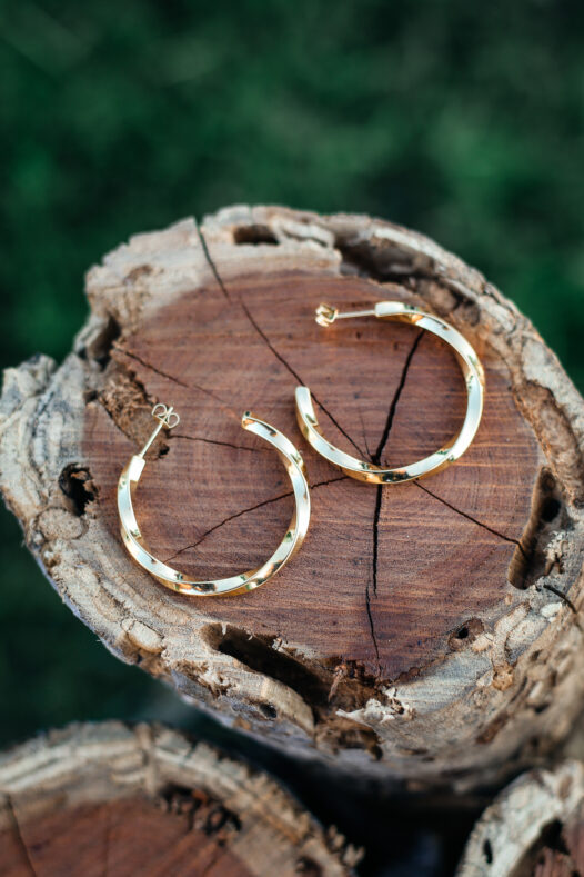 Gold Hoop earrings styled on a wood stump