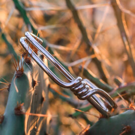 Silver wrap bangle styled against a desert background