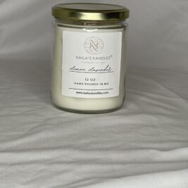 this is a clear glass jar with a gold top filled with fragrant candle wax. On the front is a white label with the name Kaila's Kandles and 12 ounces