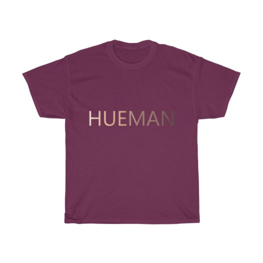 Picture of a Maroon t-shirt with the word Hueman on it that is skin-colored hues from dark skin tones to light skin tones.