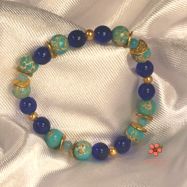 'Amphitire' Bracelet - Hibiscus by Elle Beautiful blue and gold bracelet on a white silk background. Stackable bracelets. Beaded bracelets.