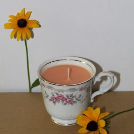 peach-colored teacup candle with Black-Eyed Susan flowers