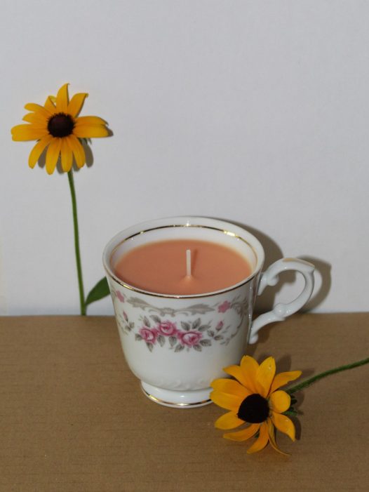peach-colored teacup candle with Black-Eyed Susan flowers