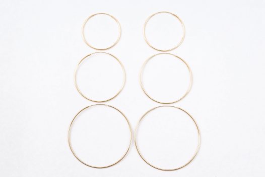 Three size comparison of the 14k gold Amor Deus Gold Classic Hoop Earrings.