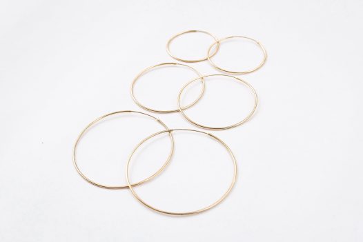 Three size comparison of the 14k gold Amor Deus Gold Classic Hoop Earrings.
