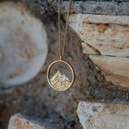 Breaking point necklace hanging from a stone backdrop