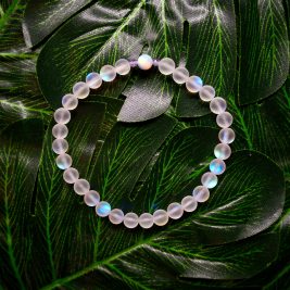A multicolored bracelet on a green floral backdrop on display