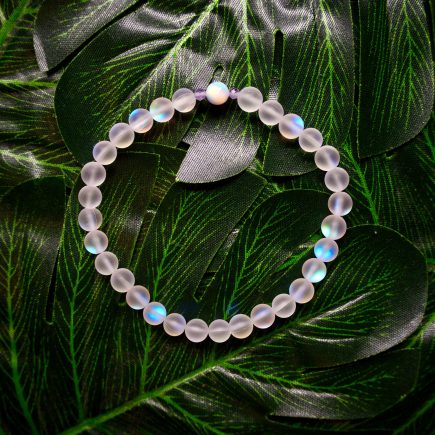A multicolored bracelet on a green floral backdrop on display