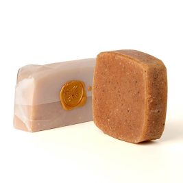 A golden yellow handcrafted bar of turmeric soap labeled “Brighten” with warm, earthy tones, designed for radiant, even-toned skin.