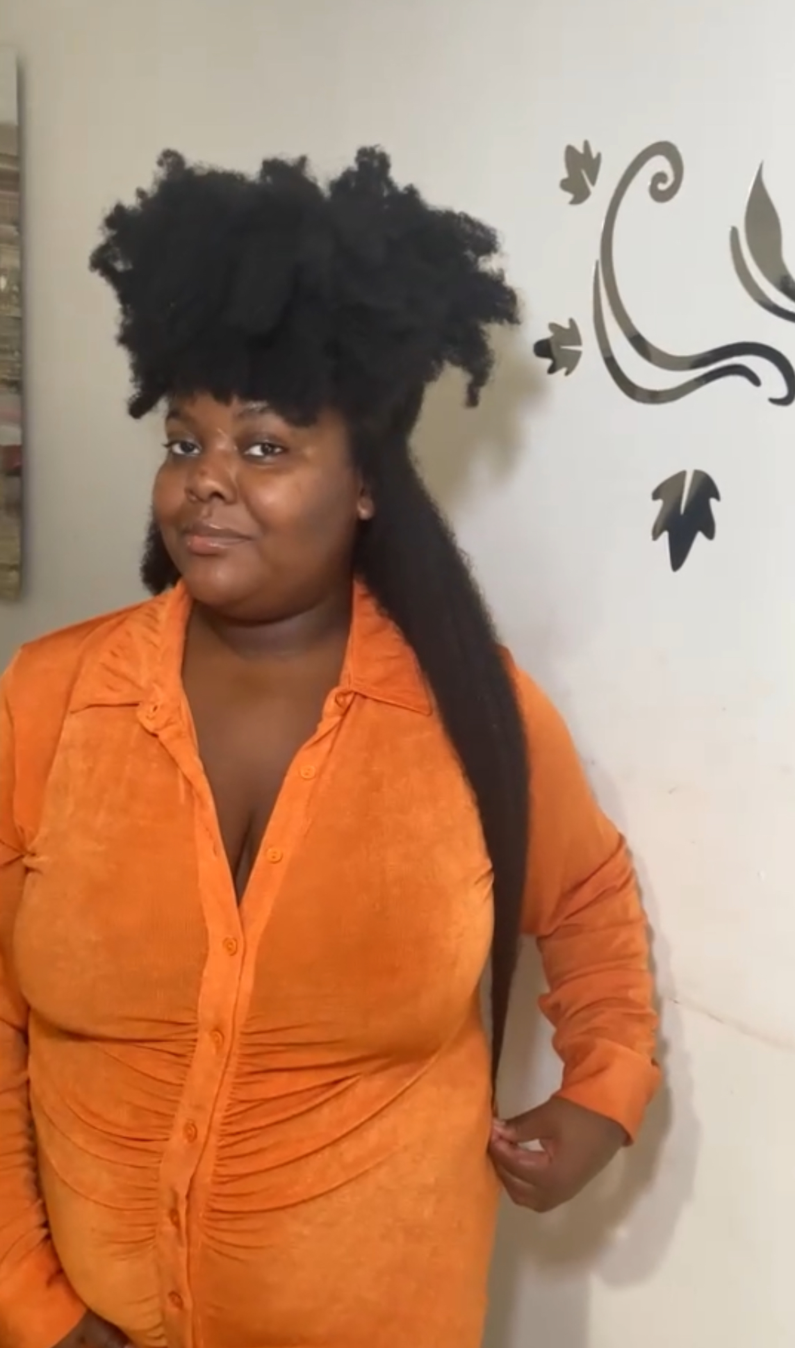 The creator of the Growth Training 101 guide pulling a portion of her hair down to her hips to show its length.